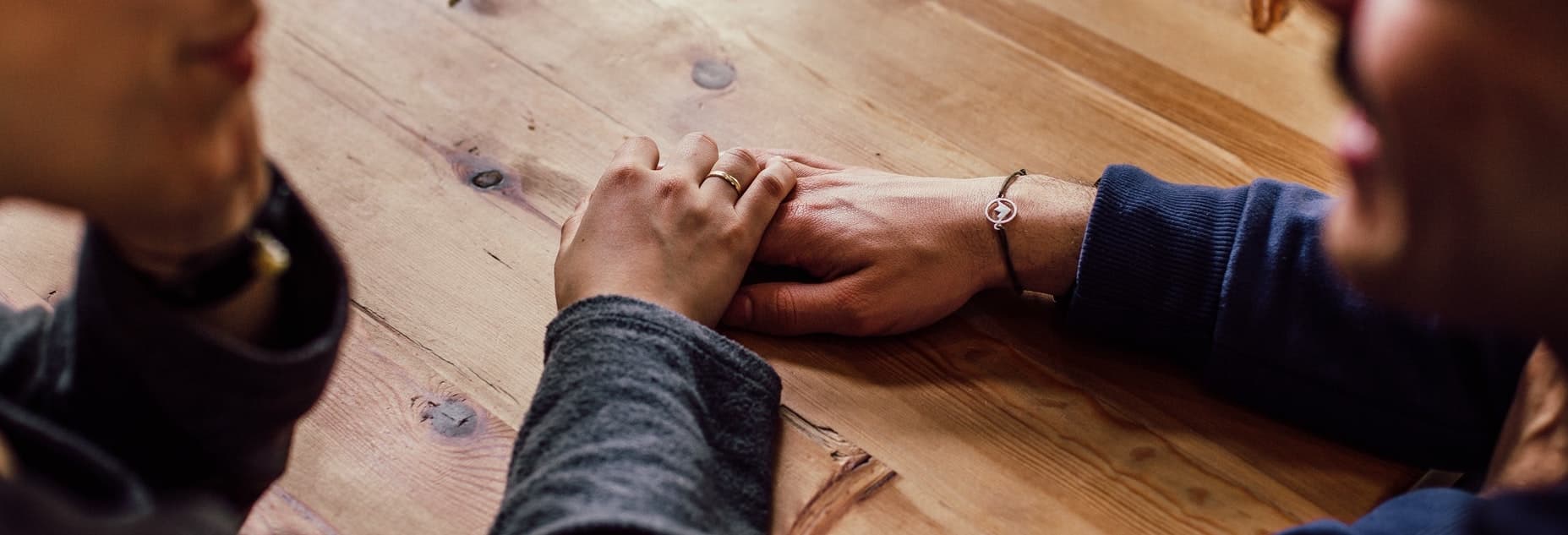 Two people holding hands in comfort